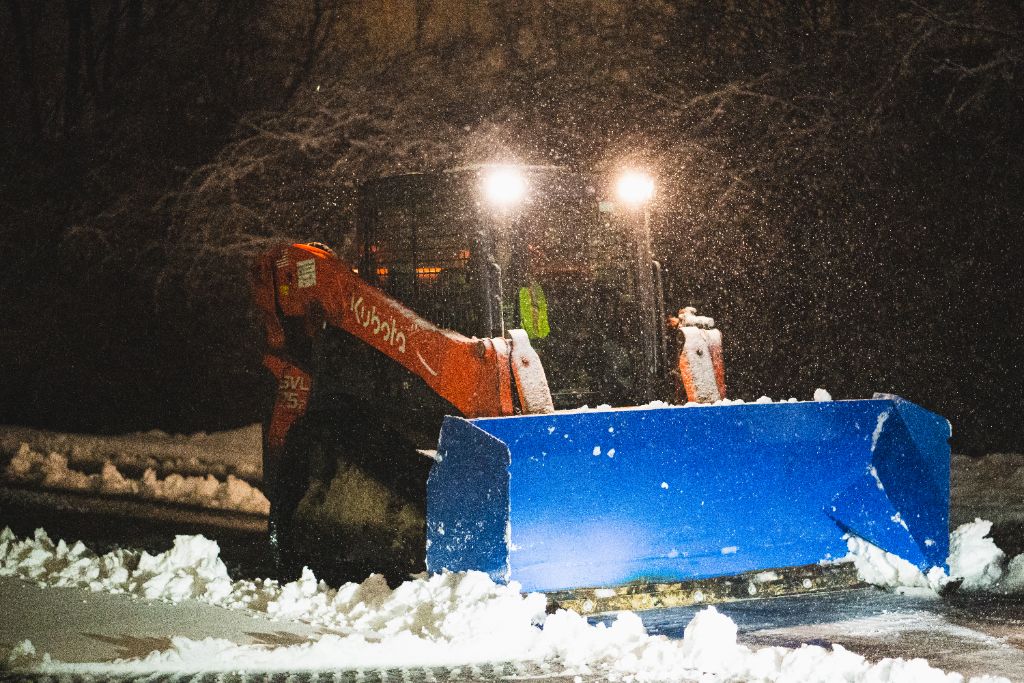 Kubota SVL loader pushing snow at night