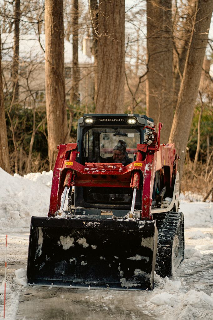 Takeuchi track loader clearing commercial parking area